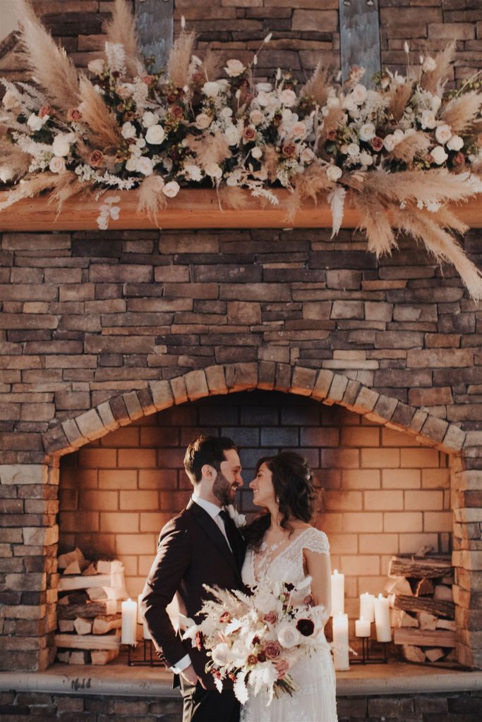 couple in front of fireplace on winter wedding day at ryland inn
