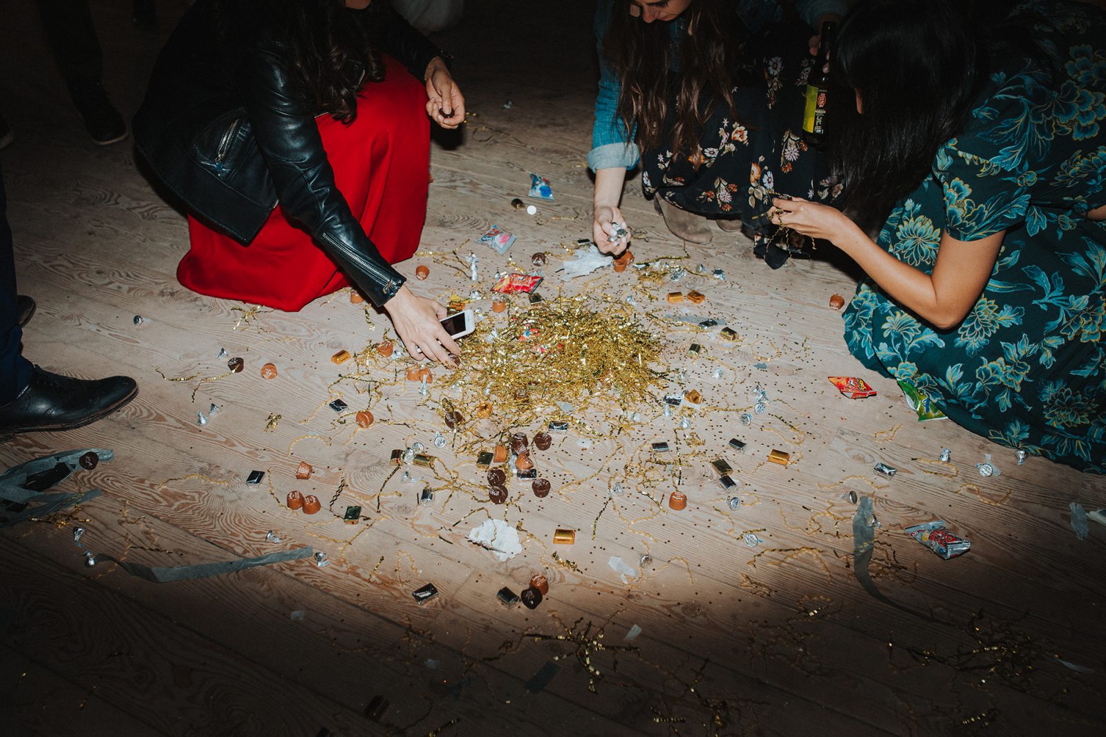 wedding guests pick up piñata candy from dance floor in catskills barn