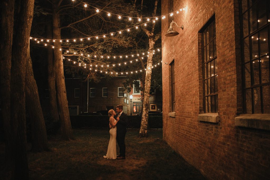 Couple underneath string lights on their wedding night at Senate Garage in the Hudson Valley. 